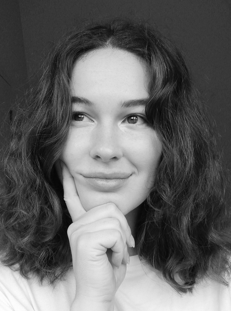 Black and white portrait of the author shows her thinking happily about something. 